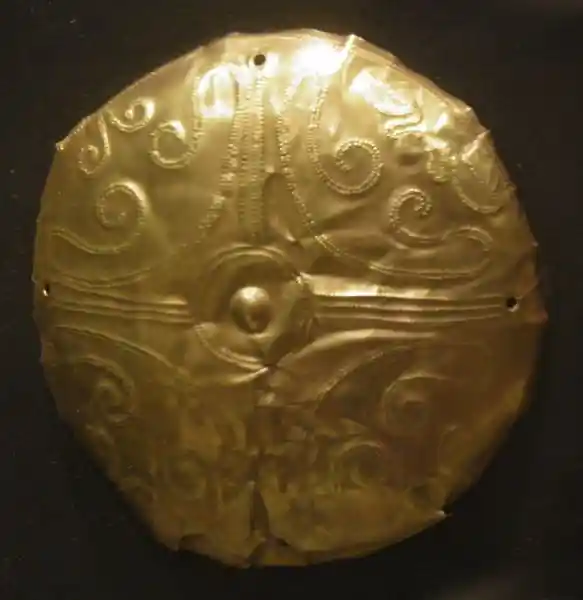 Cross with swirls engraved on a gold disc